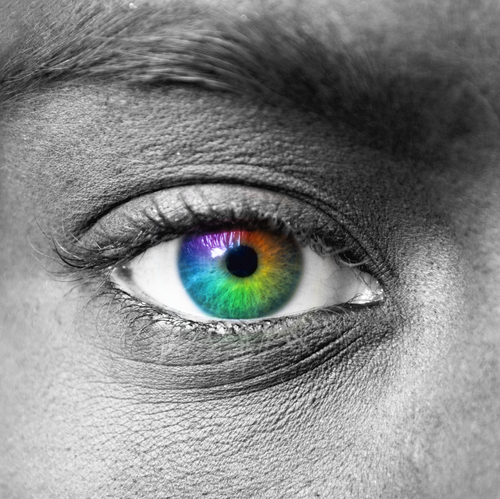 Black and white closeup of an eye. The eye itself is colored with a rainbow radial gradient.