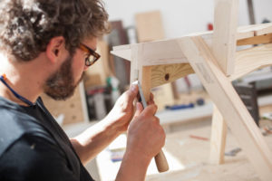 A carpenter working on a bench.