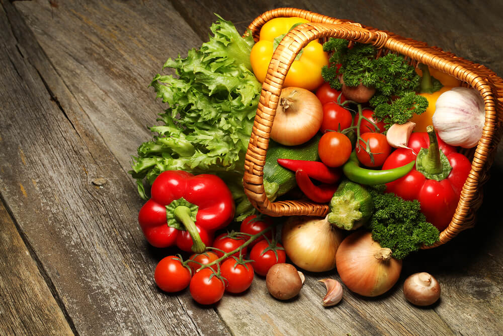Assorted Fruits and Vegetables overflowing from a basket.