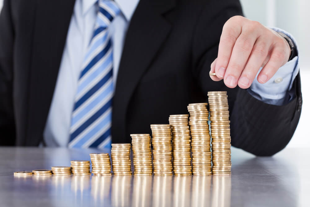 A person stacking pennies like stairs.