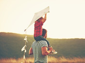 Man Flying a Kite with Son