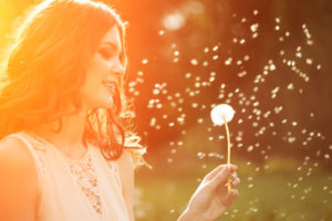 Blowing daisy seeds into the wind.