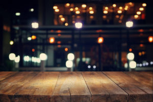 Wooden table with several lights in the background, out of focus. Nice circular bokeh.