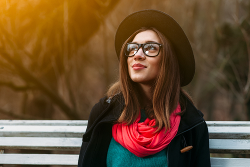 Young trendy woman wearing glasses and a hat