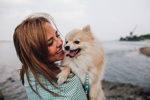 Young woman celebrating with her dog after LASIK