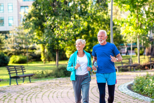 Older couple walking through a park