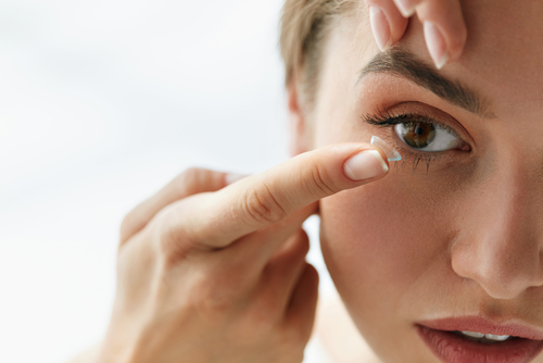 Woman putting in contact lenses