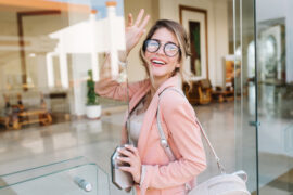 Woman waving walking through glass doors