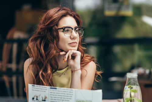 woman wearing glasses while sitting at restaurant 